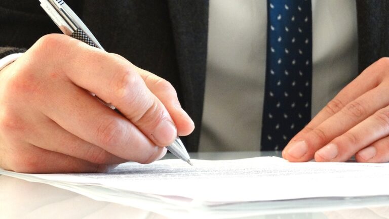 A man in a suit - a lawyer signing a legal document